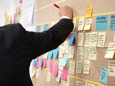 business man working on a projectboard with post its